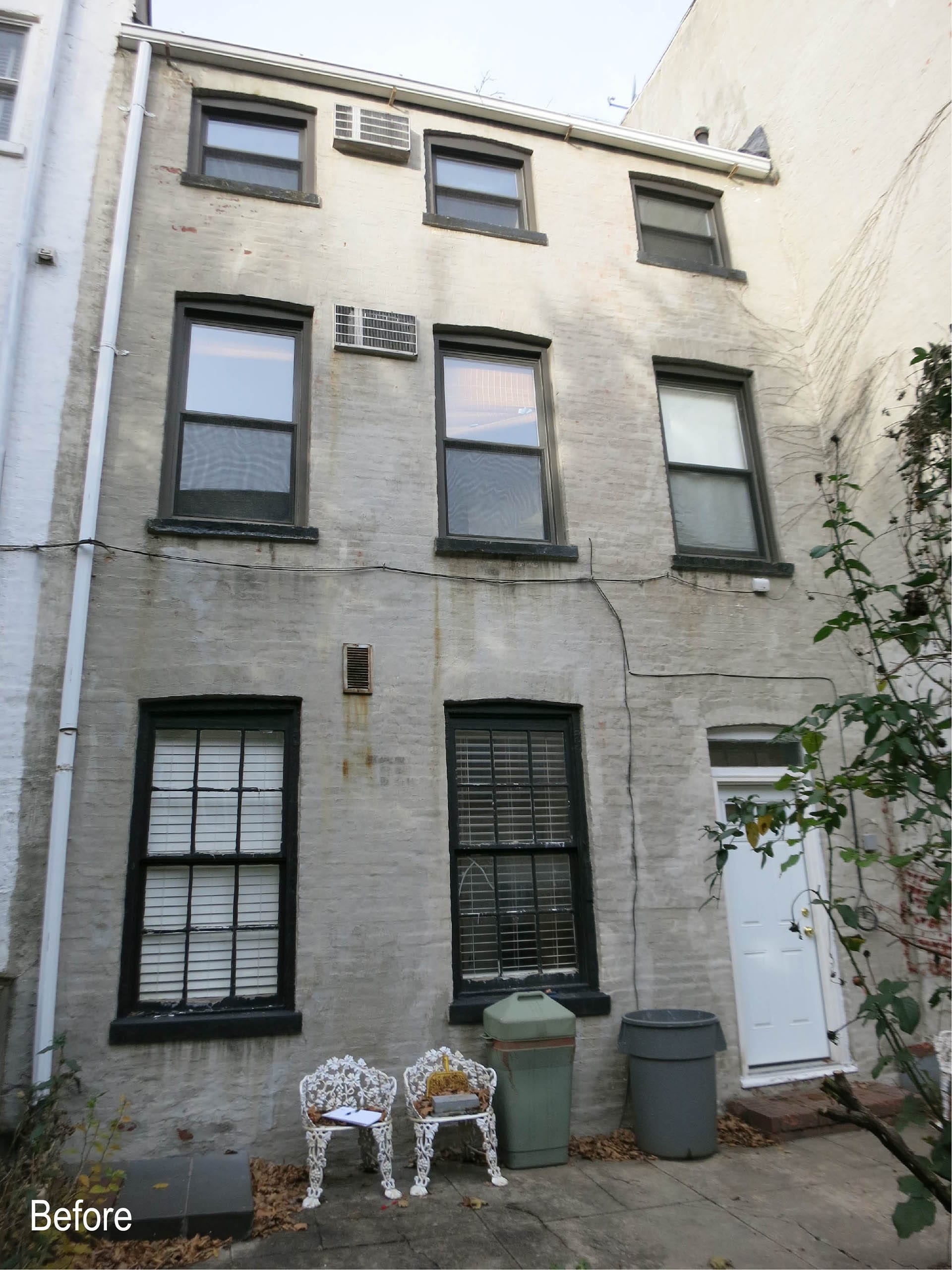 Coated brick rear façade of a colonnade rowhouse before our renovation.